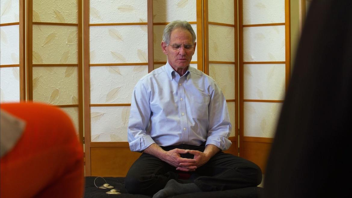 Man sits in a room meditating