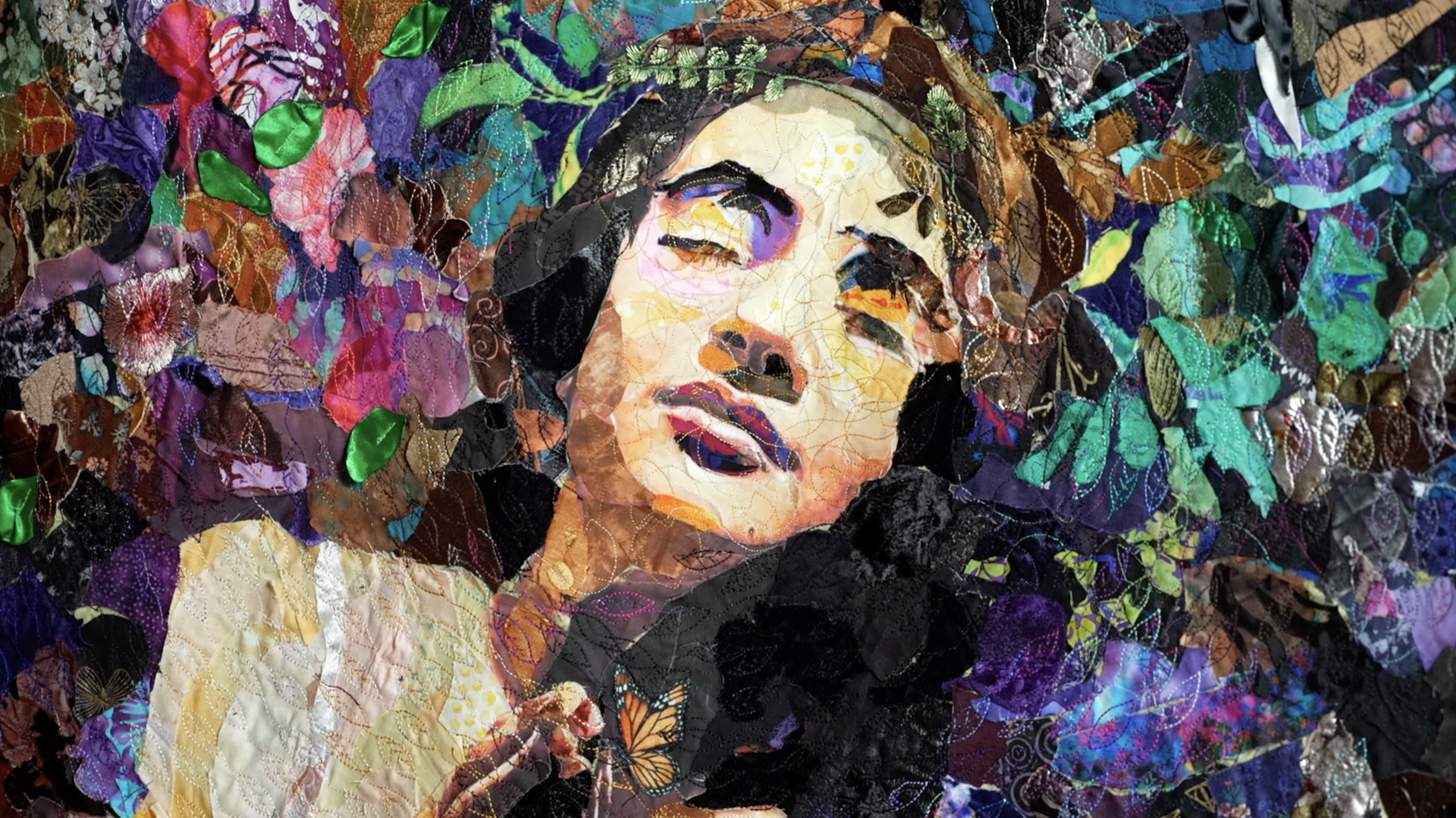 A textile collage portrait of a woman gazing upward, her face constructed from layered and stitched fabric scraps. She is surrounded by a lush, colorful array of fabric flowers, leaves, and foliage in purples, greens, pinks, and teals. A monarch butterfly rests near her hand in the lower foreground.