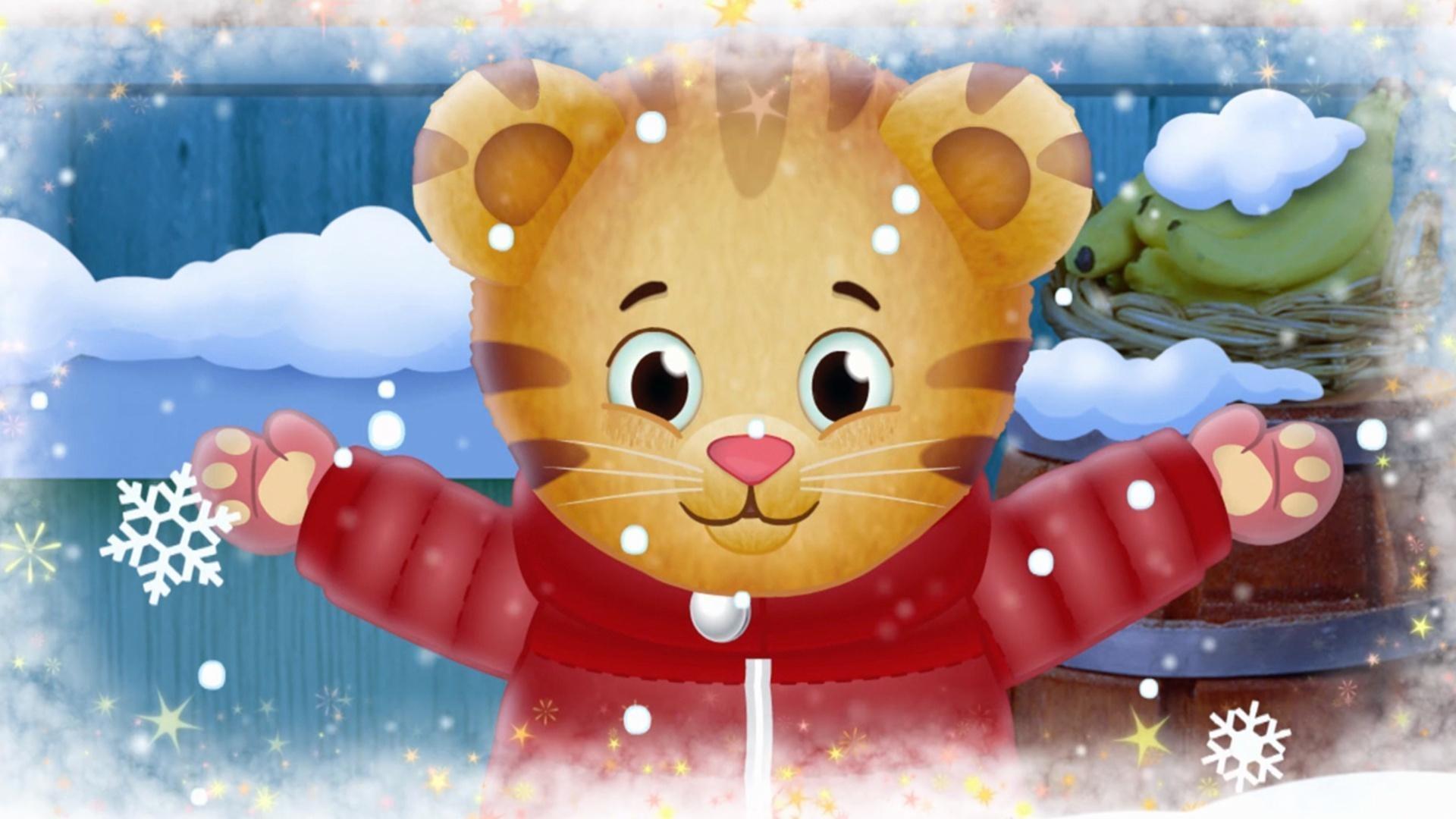 Cartoon image of Daniel Tiger - an orange tiger wearing a puffy red jacket. Daniel Tiger poses with his arms outstretched as snow falls around him