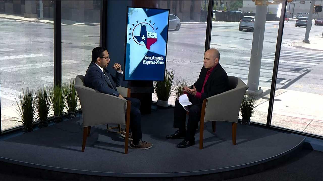 Texas Talk host Gilbert Garcia and State Rep. Diego Bernal sit opposite one another in two chairs. Between them, the "Texas Talk" logo is displayed on a screen. 