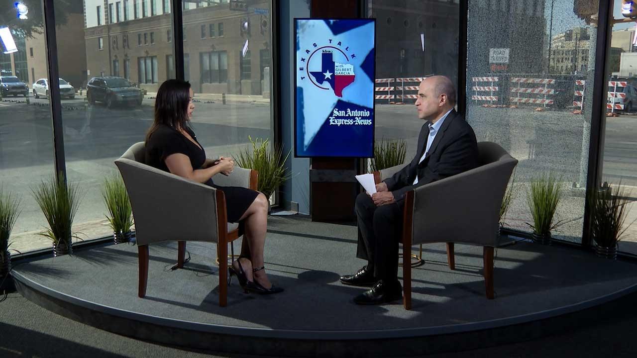 Texas Talk host Gilbert Garcia sits in a chair on the right. Across from him sits a woman, Josey Garcia, Texas Rep. for District 124. 