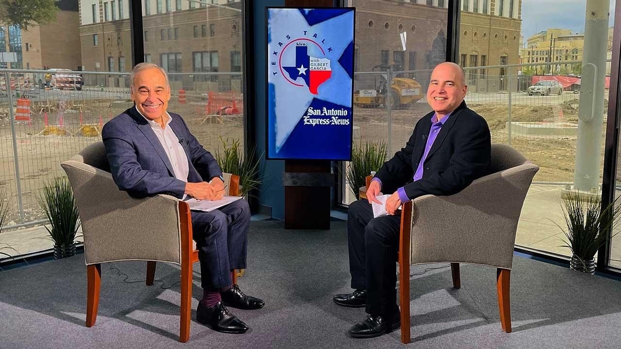 Texas Talk host Gilbert Garcia and guest Charlie Gonzalez (seated left) smile at the camera.