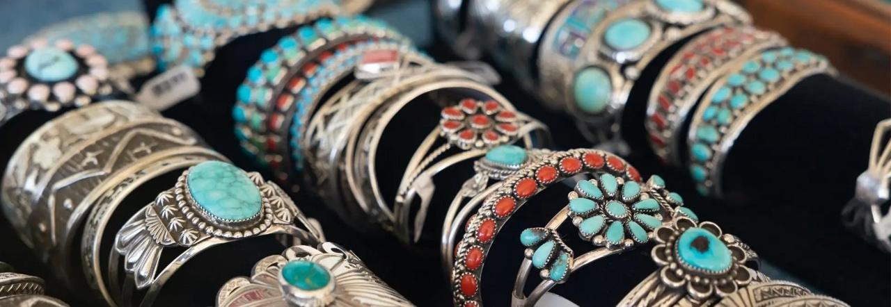 Rows of Navajo-style silver and turquoise bracelets on a table display