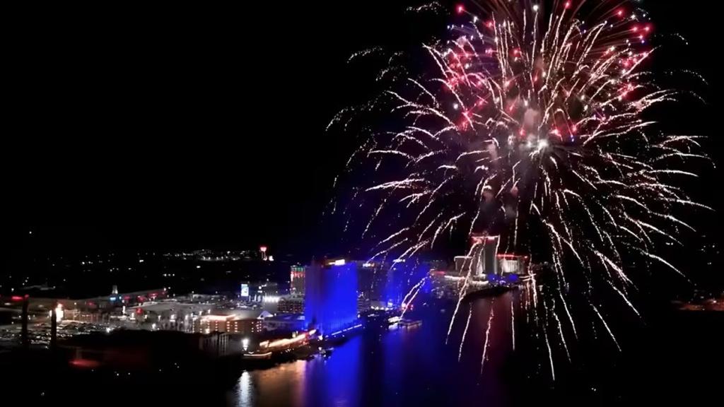 Fireworks exploding at night over the Colorado River with the Laughlin skyline in the background