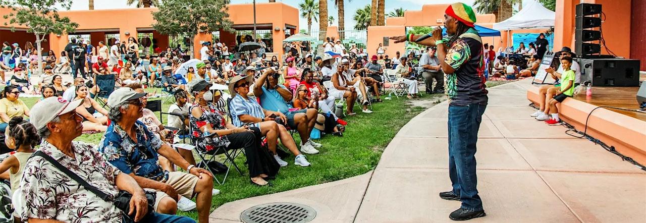 Caribbean Heritage Festival outdoor performance stage with crowd sitting in lawn chairs