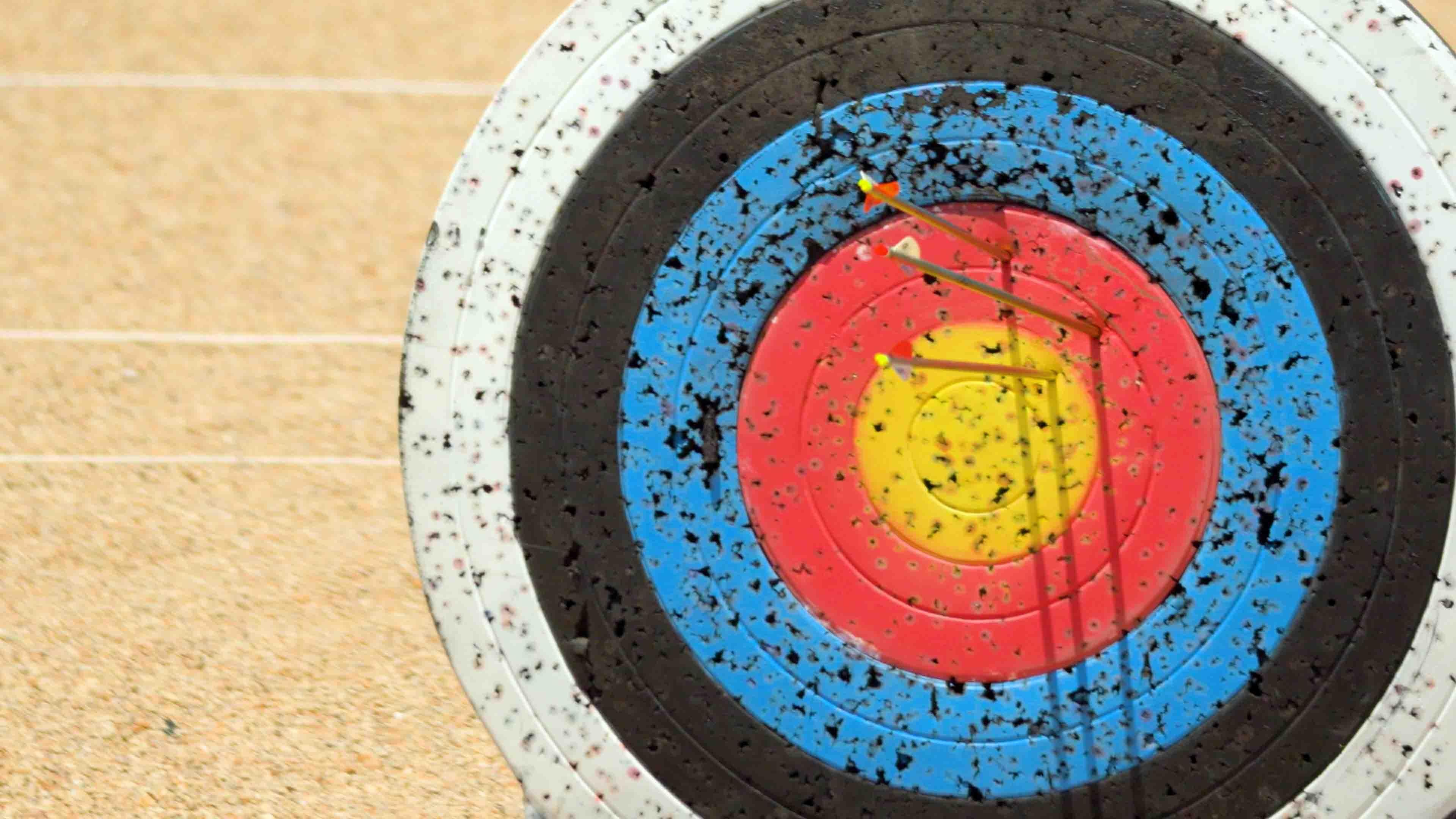 Three arrows stuck in an archery bullseye target