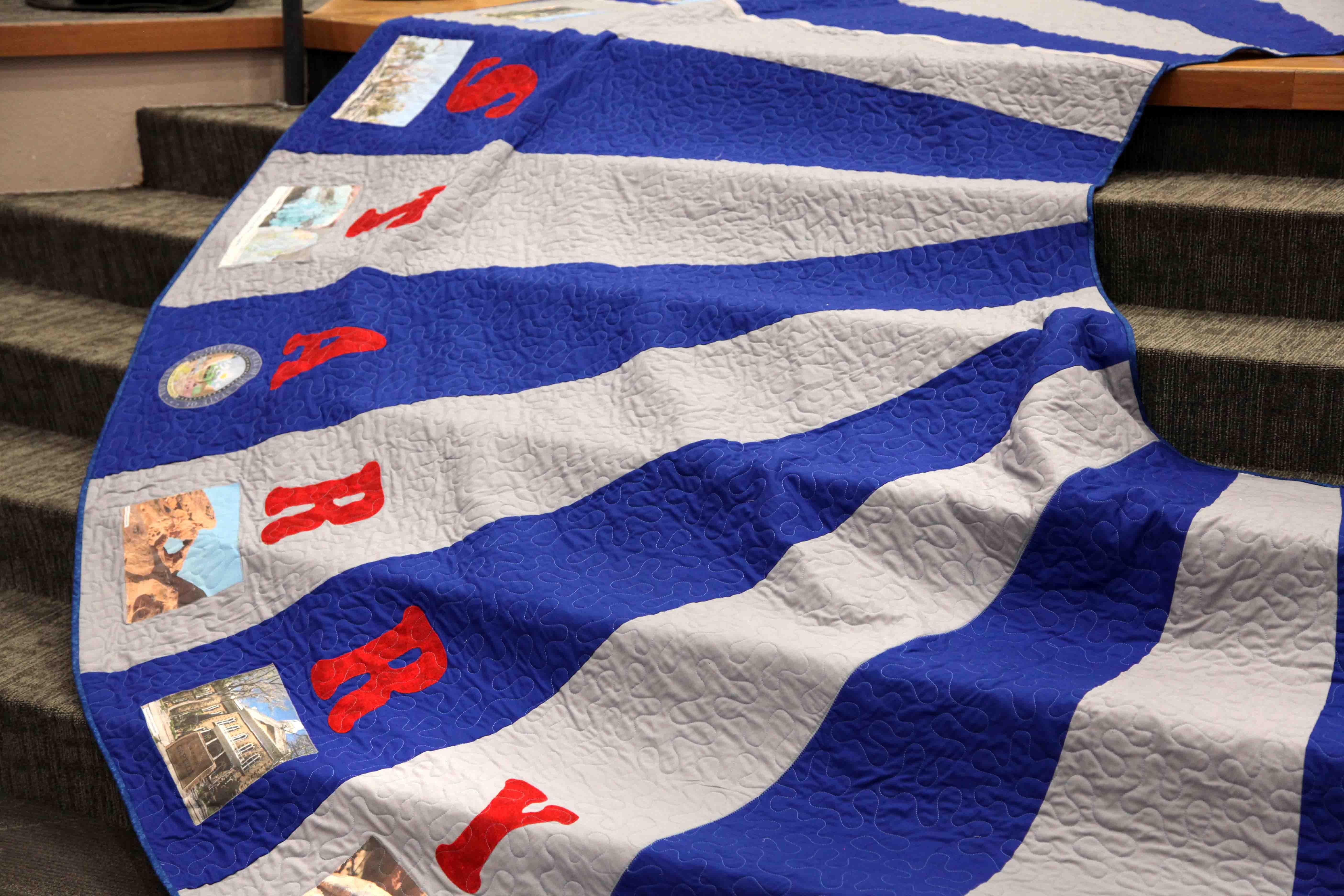 Detail of a quilted Christmas tree skirt with sewn letters that spell out "STARRY"