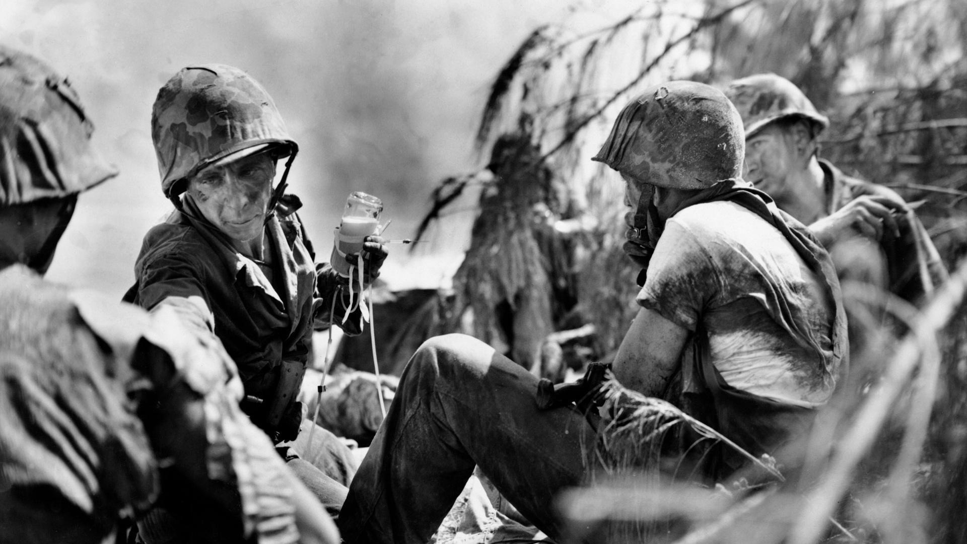 WW 2 photo of soldiers and a medic holding and IV.