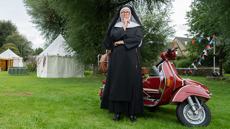 The Catholic nun "Sister Boniface" stands in front of her Vespa.