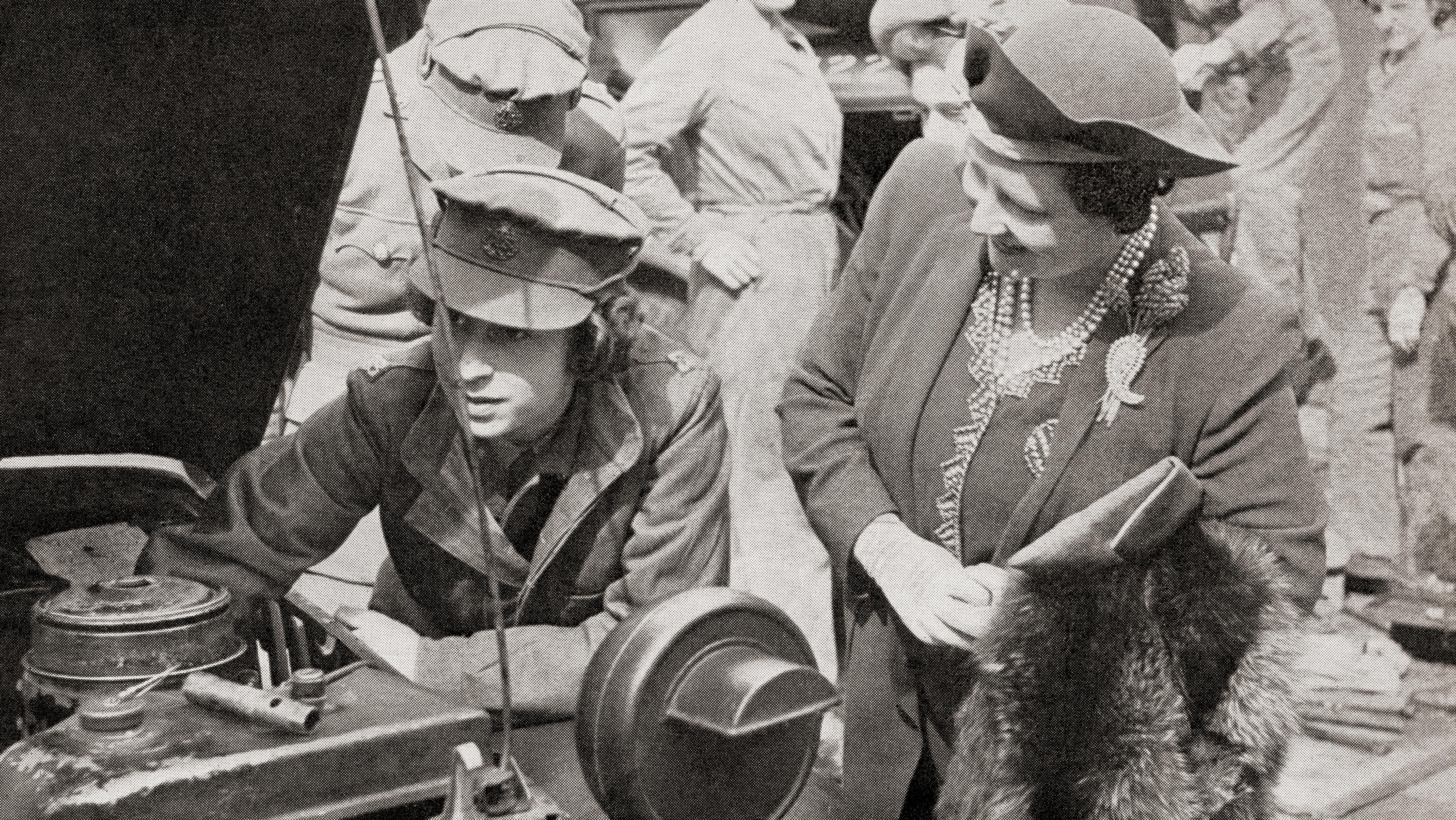 Queen Elizabeth Bowes-Lyon and looking over the shoulder of an auto mechanic.