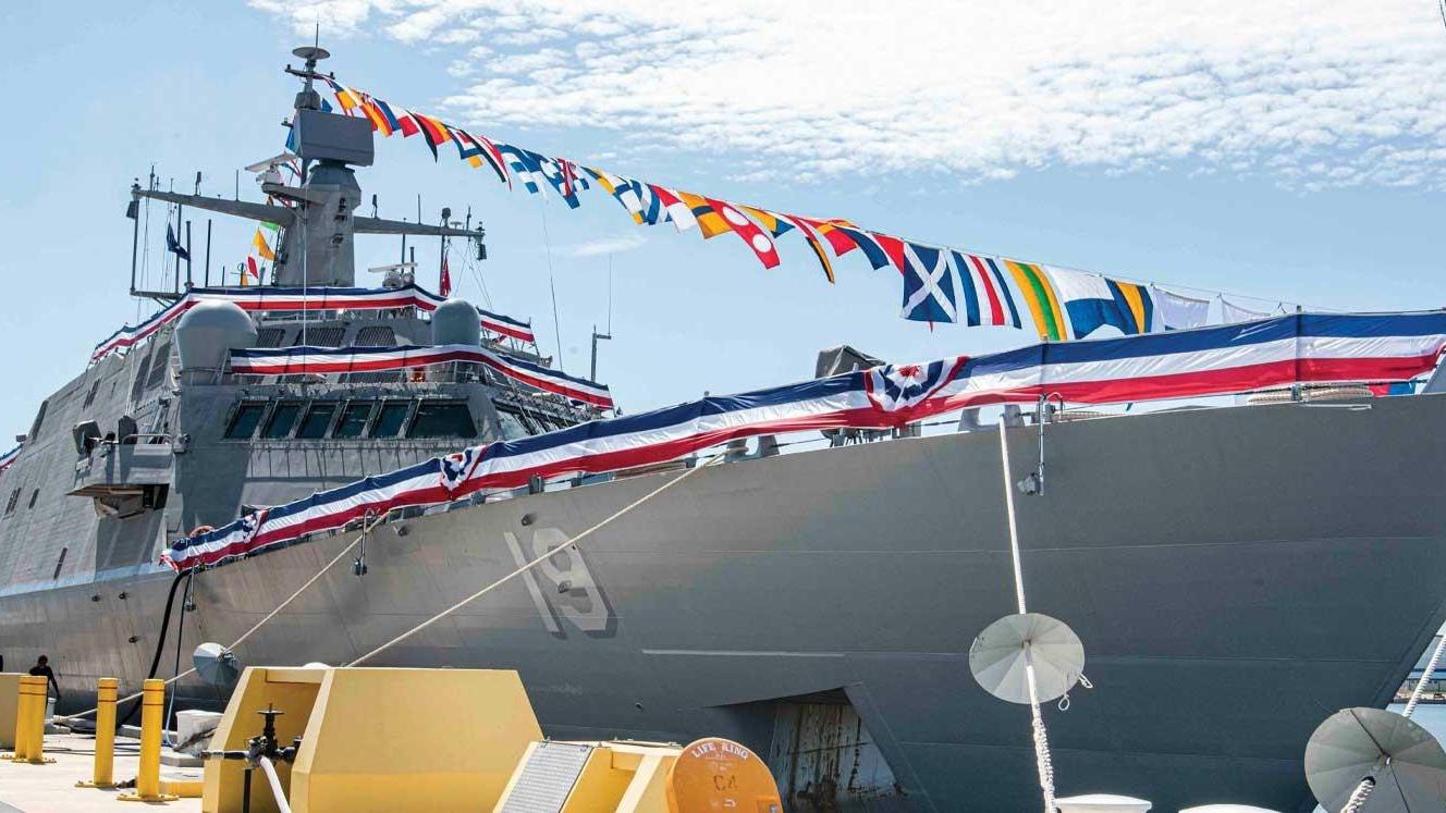 USS St. Louis, docked, with red, white and blue bunting on the railing.