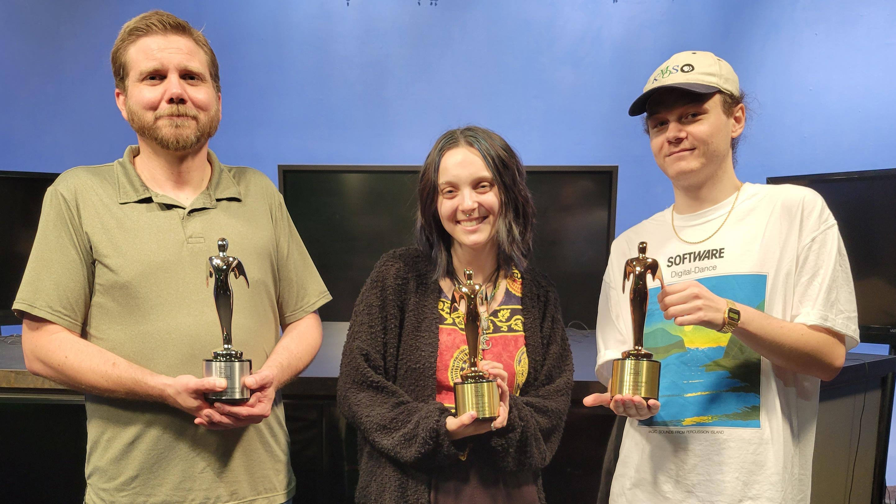 A KMOS staff member and two students hold Telly awards.