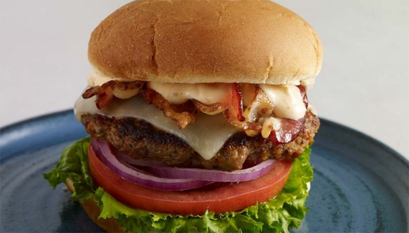 A close up of a delicious burger sitting on a plate.