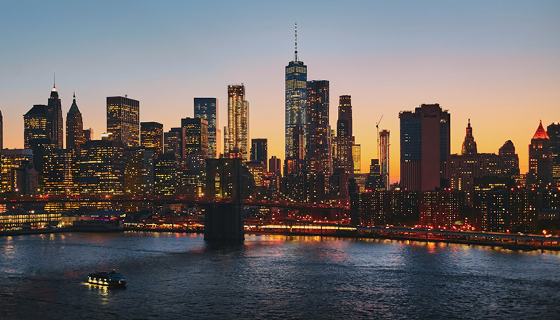 New York City at sunset with all the city's lights on.