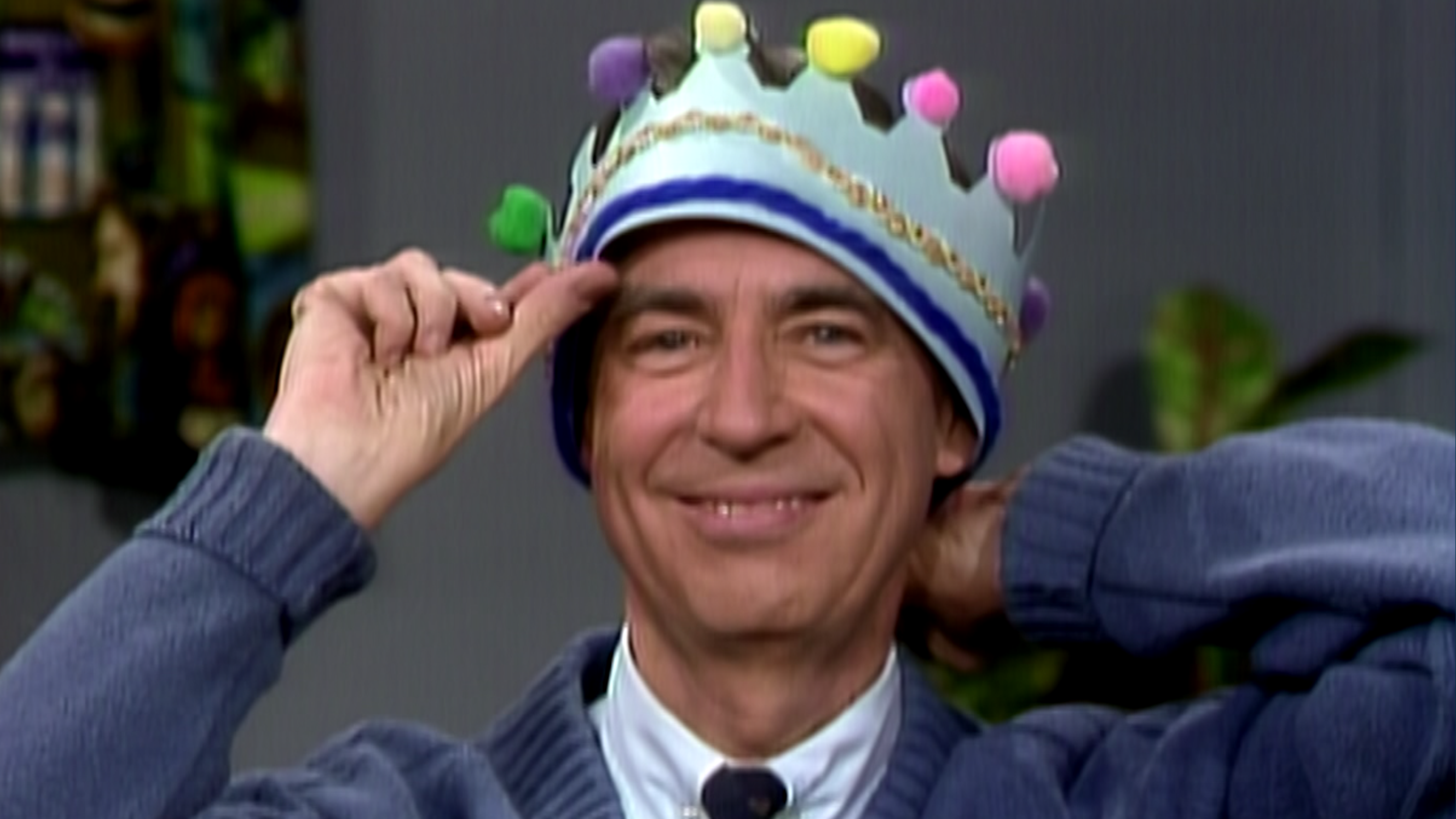Mr. Rogers smiling with with a handmade paper crown on his head.