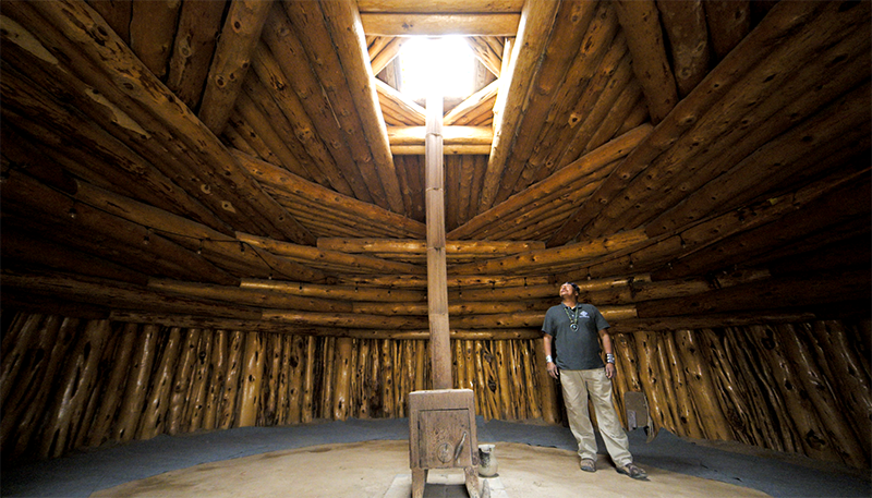 Robert Nutlouis stands in a completed hogan in Navajo Nation.