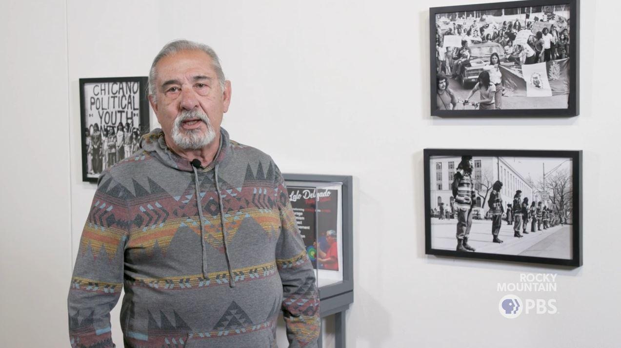 Juan Espinoza stands in front of his photographs, which predominantly focus on the Chicano civil rights movement in Colorado. His work is on display at the El Pueblo History Museum.