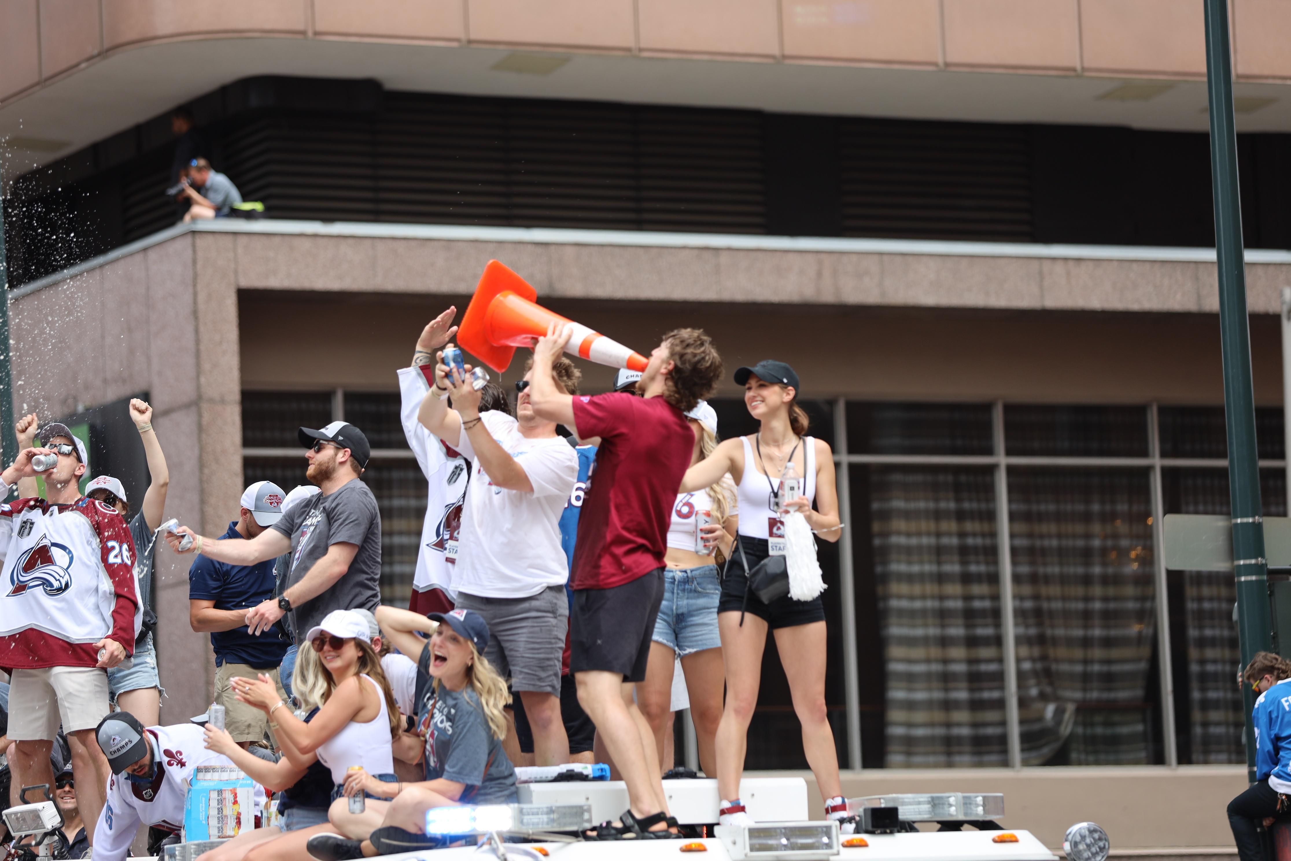 Fans reach out to touch the Stanley Cup as Colorado Avalanche defenseman Bowen  Byram, front, brings it to the crowd during a rally outside the City/County  Building for the NHL hockey champions