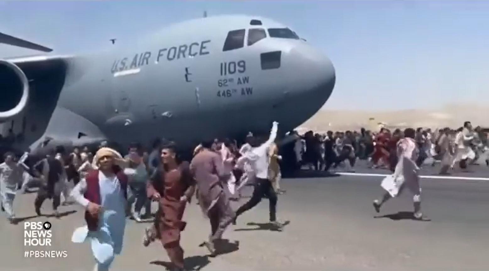 Hundreds of Afghans race after a U.S. Air Force plane leaving the airport in Kabul, Afghanistan. Seven people died in the chaos.