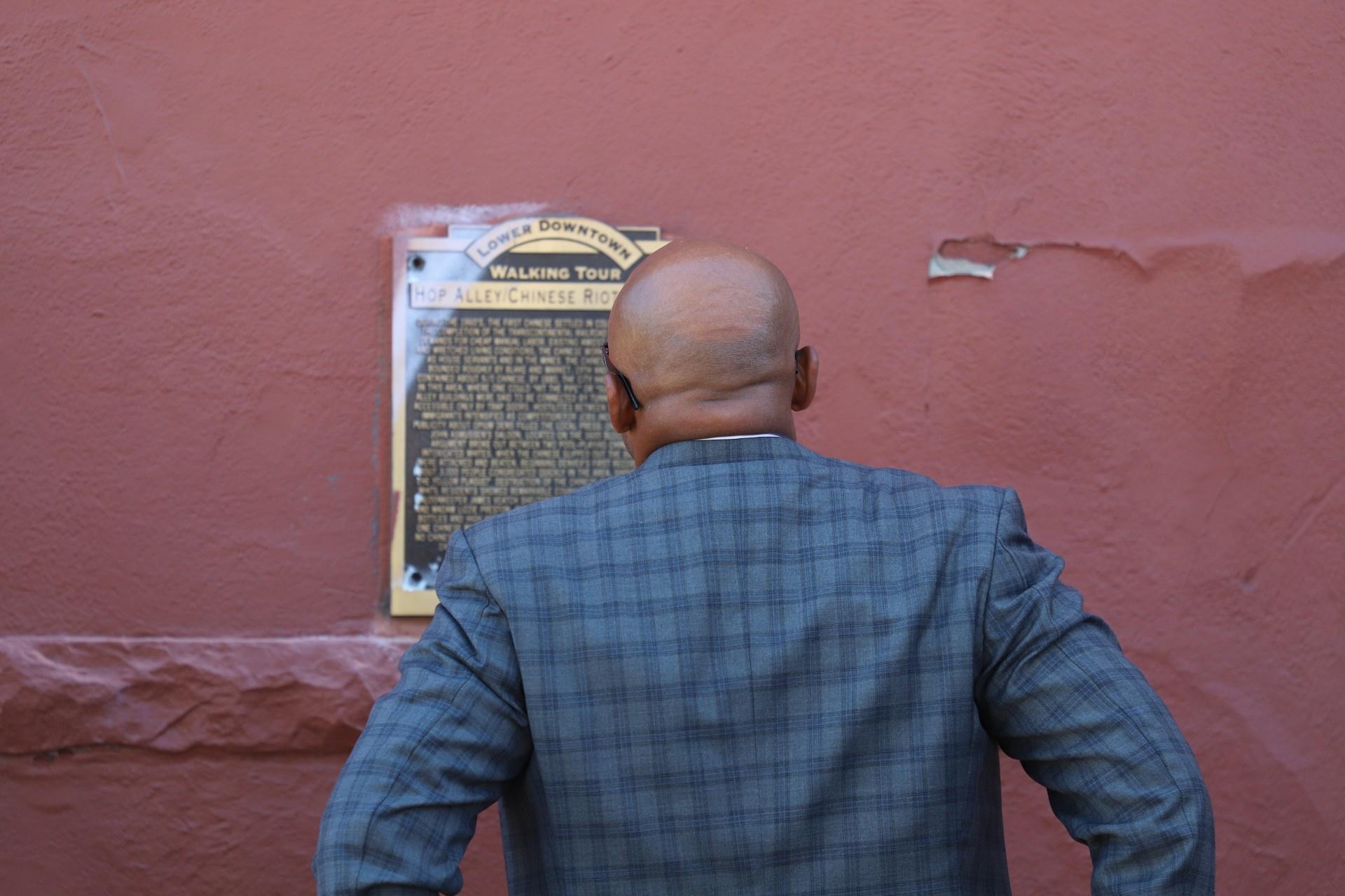 Denver Mayor Michael B. Hancock reads the plaque before it was taken down Monday, August 8, 2022.