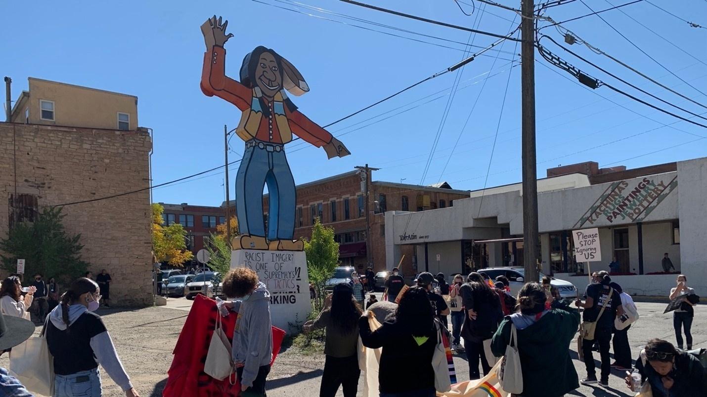 Under a banner of #NotYourMascotDurango, more than 80 people marched in Durango for Indigenous People’s Day – with a goal of removing the cartoonish “Chief” statue prominently located downtown.