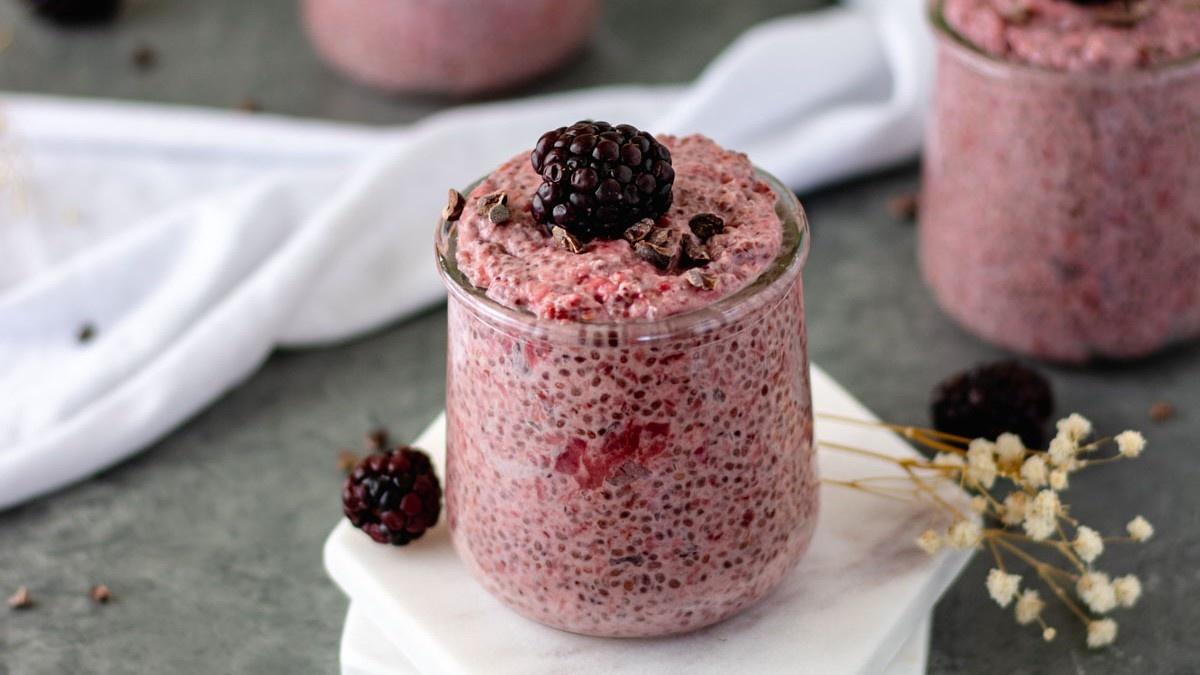 Roasted Strawberry Chia pudding in pinch bowl topped with one blackberry and cacao nibs