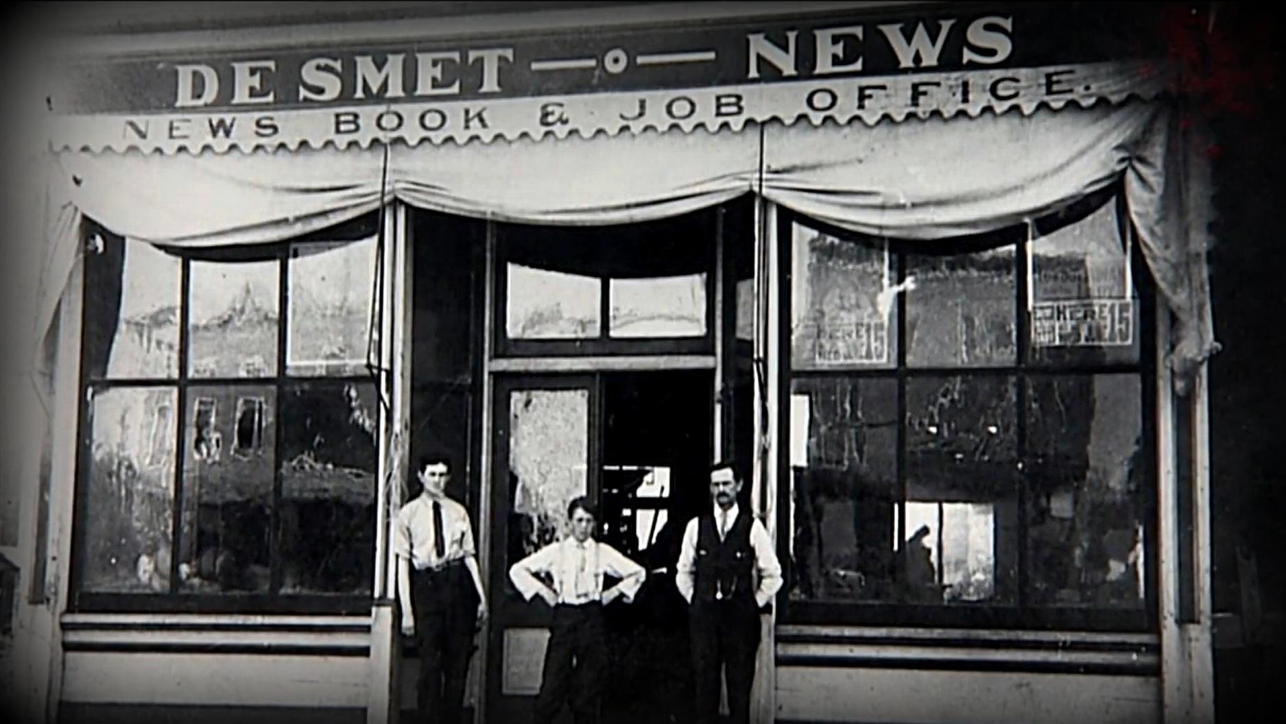  Archival photo of three men standing in front of the De Smet News building.