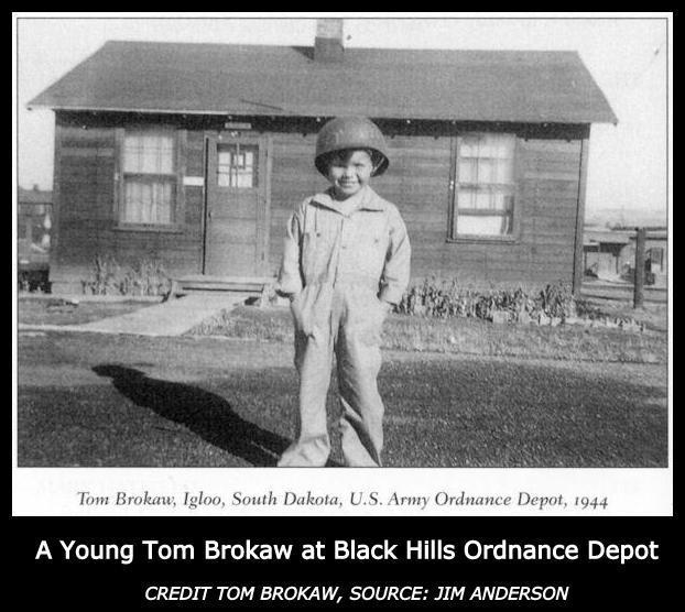 A young Tom Brokaw wearing a jumpsuit and military helmet standing in front of a small house, Igloo, South Dakota, 1944. 