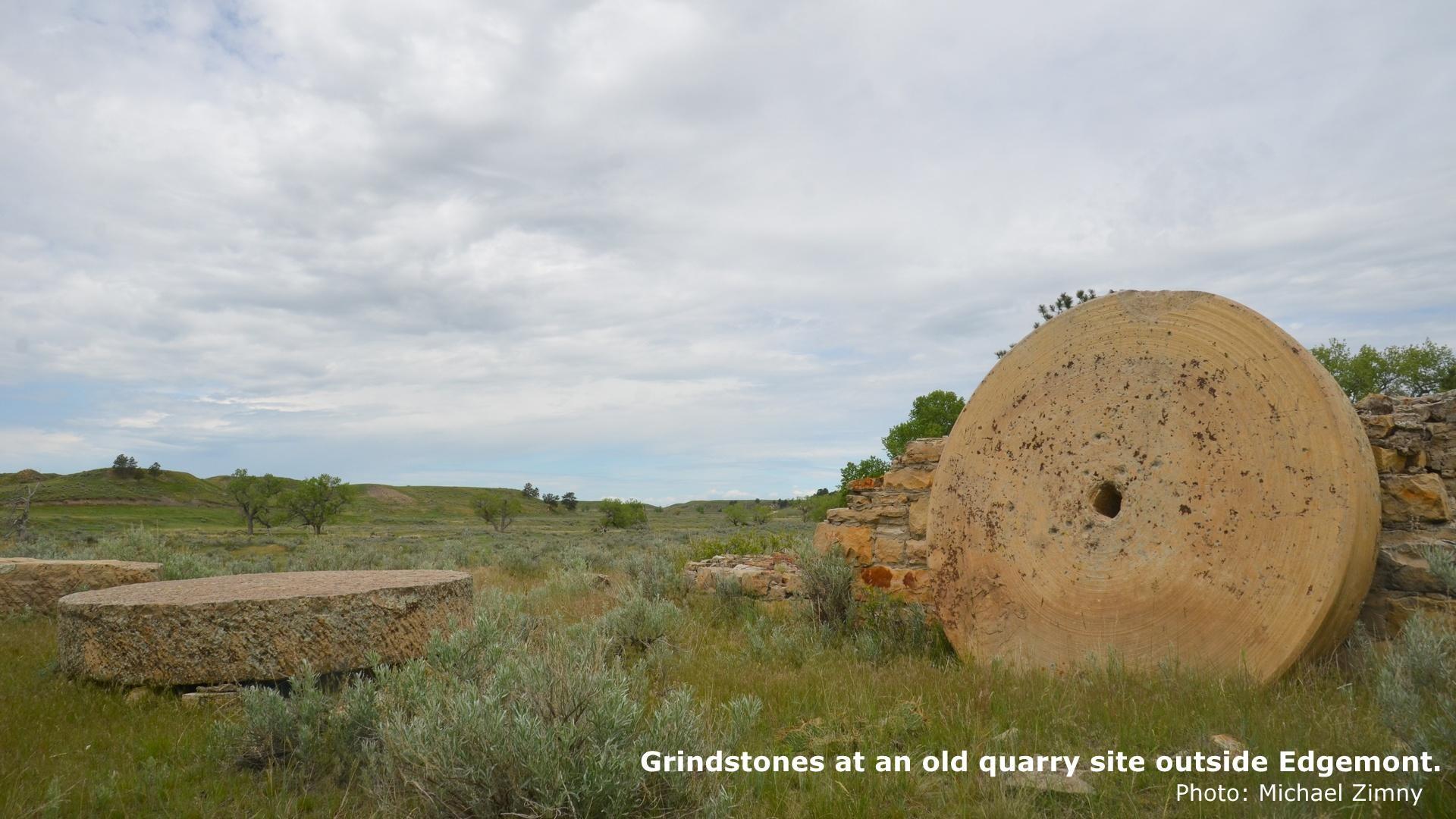  Three large grindstones sit on the grass-covered ground near Edgemont, South Dakota. 