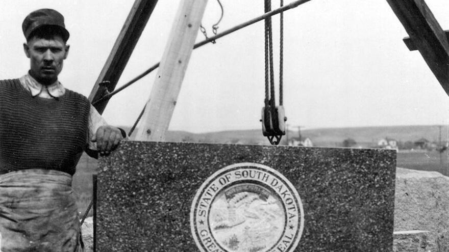A man beside the pulley system lifted the South Dakota Commemorative Stone at the Washington Monument. 