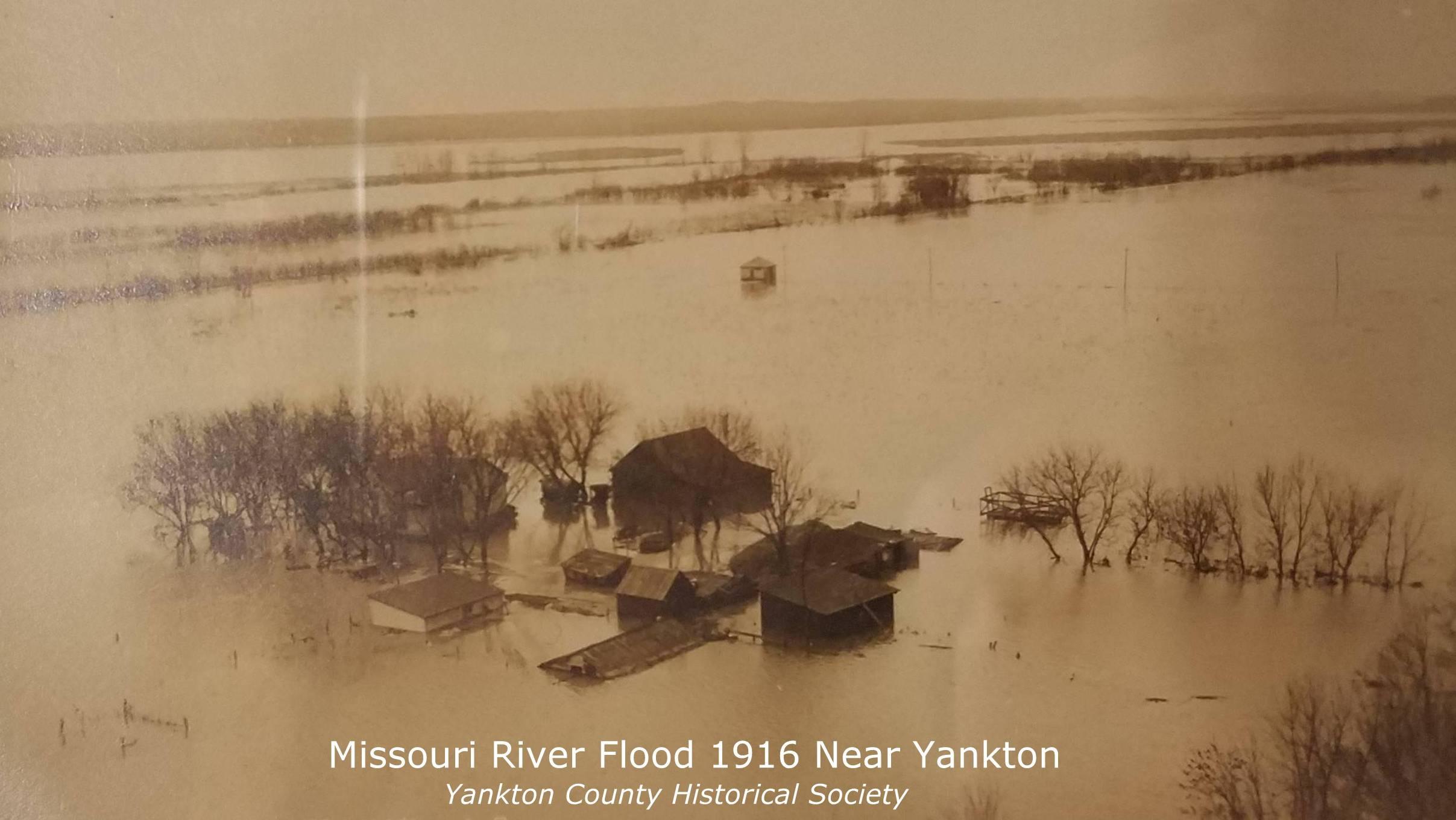 Archival photo of a 1916 flood near Yankton, SD. A farm is shown surrounded by flood water. 
