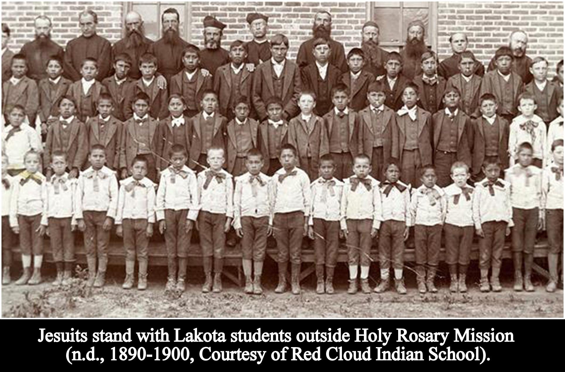 Archival photo - Jesuits stand with Lakota students outside Holy Rosary Mission. 