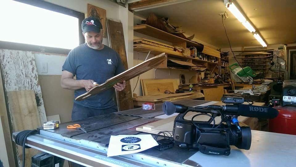 Craig McCollum works on one of his custom longboards