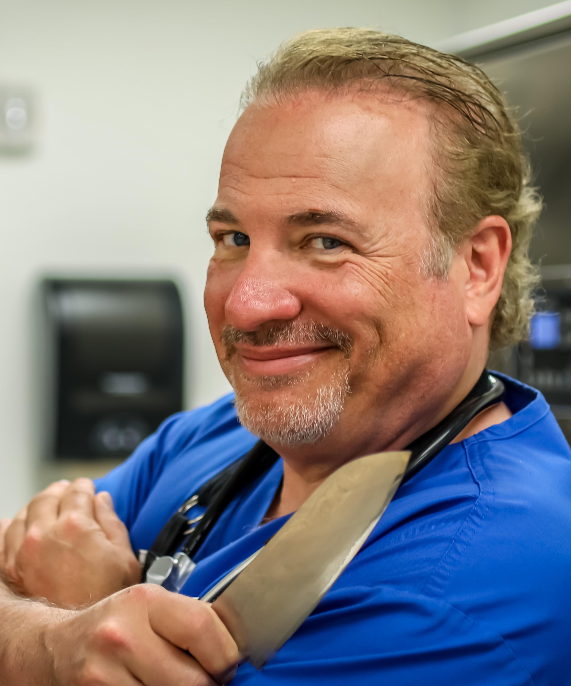 Image of Chef Dr. Mike holding a chef's knife and smiling