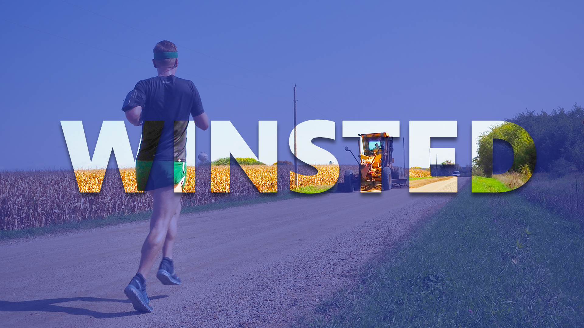 Photo of Mikah Meyer running by a tractors and a corn field.
