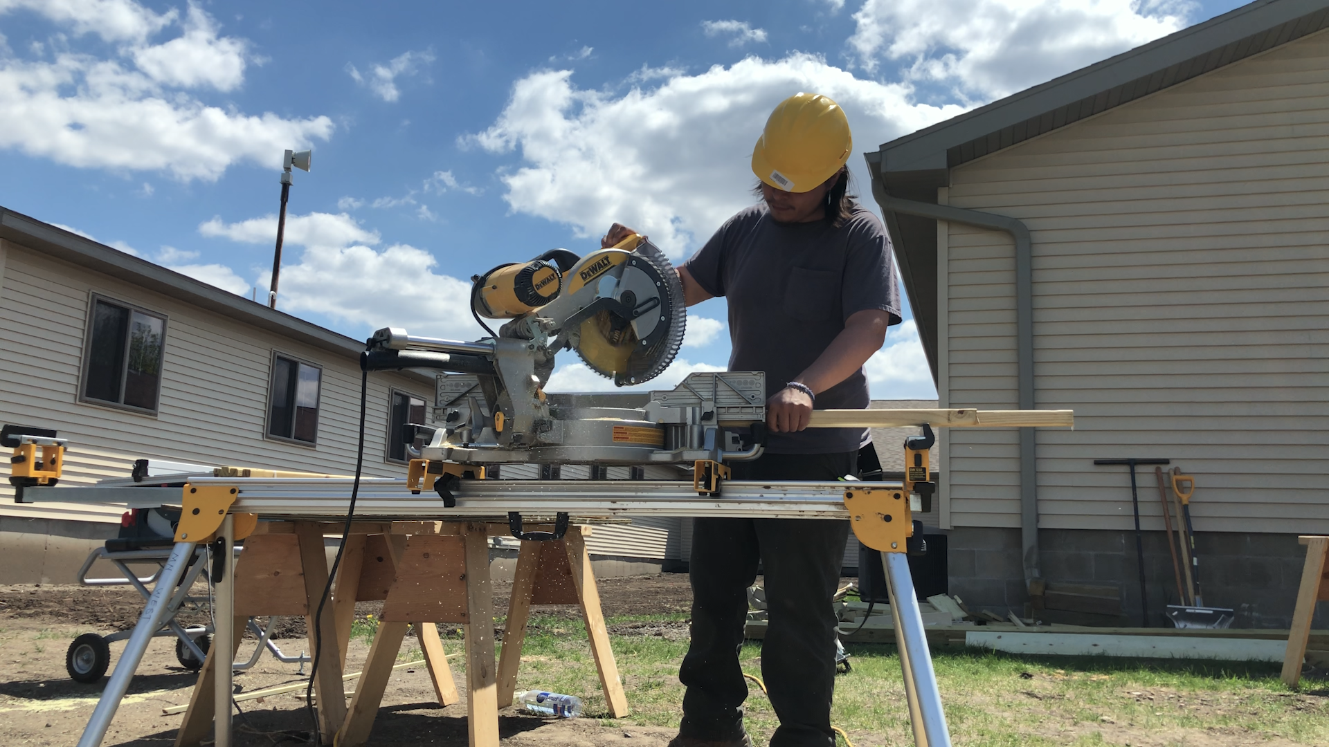 A photo of a student in the construction trades using a saw.