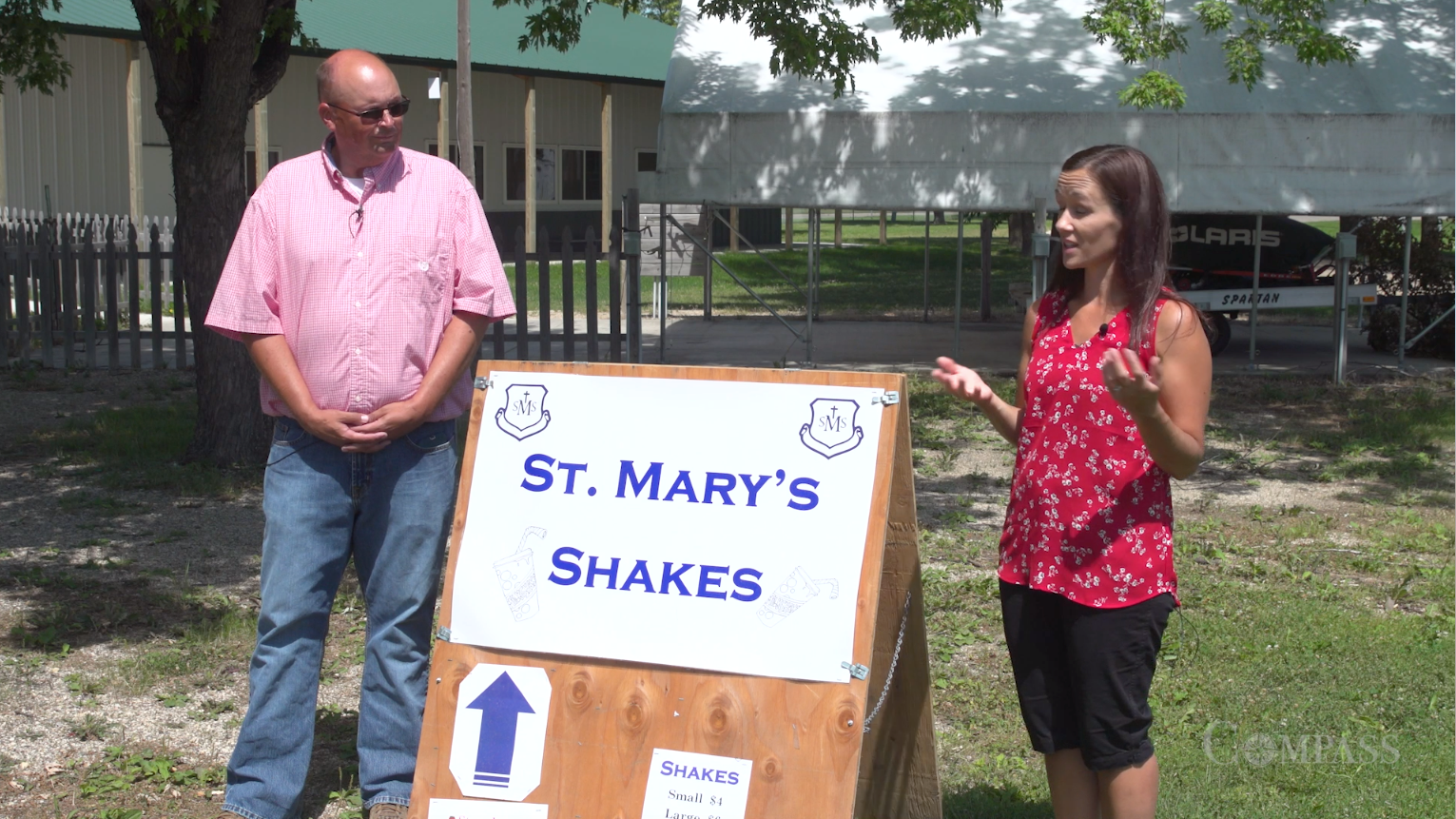 Ryan Sleiter and Tanya Fisher standing front of a board that says, "St. Mary's Shakes."