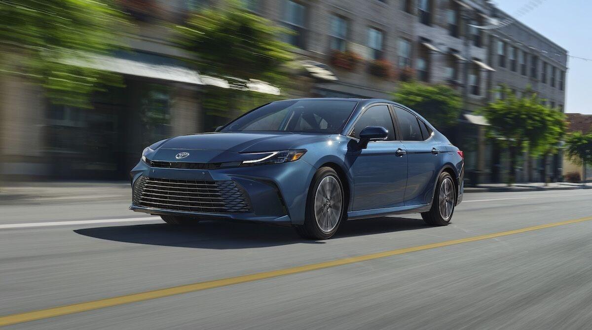 2026 Toyota Camry LE Hybrid on Road with City Background