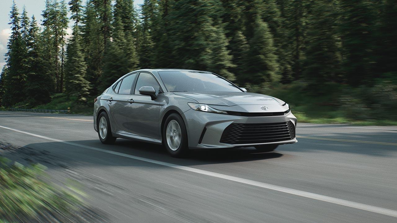 2026 Toyota Camry LE Hybrid on Road with Forest Background