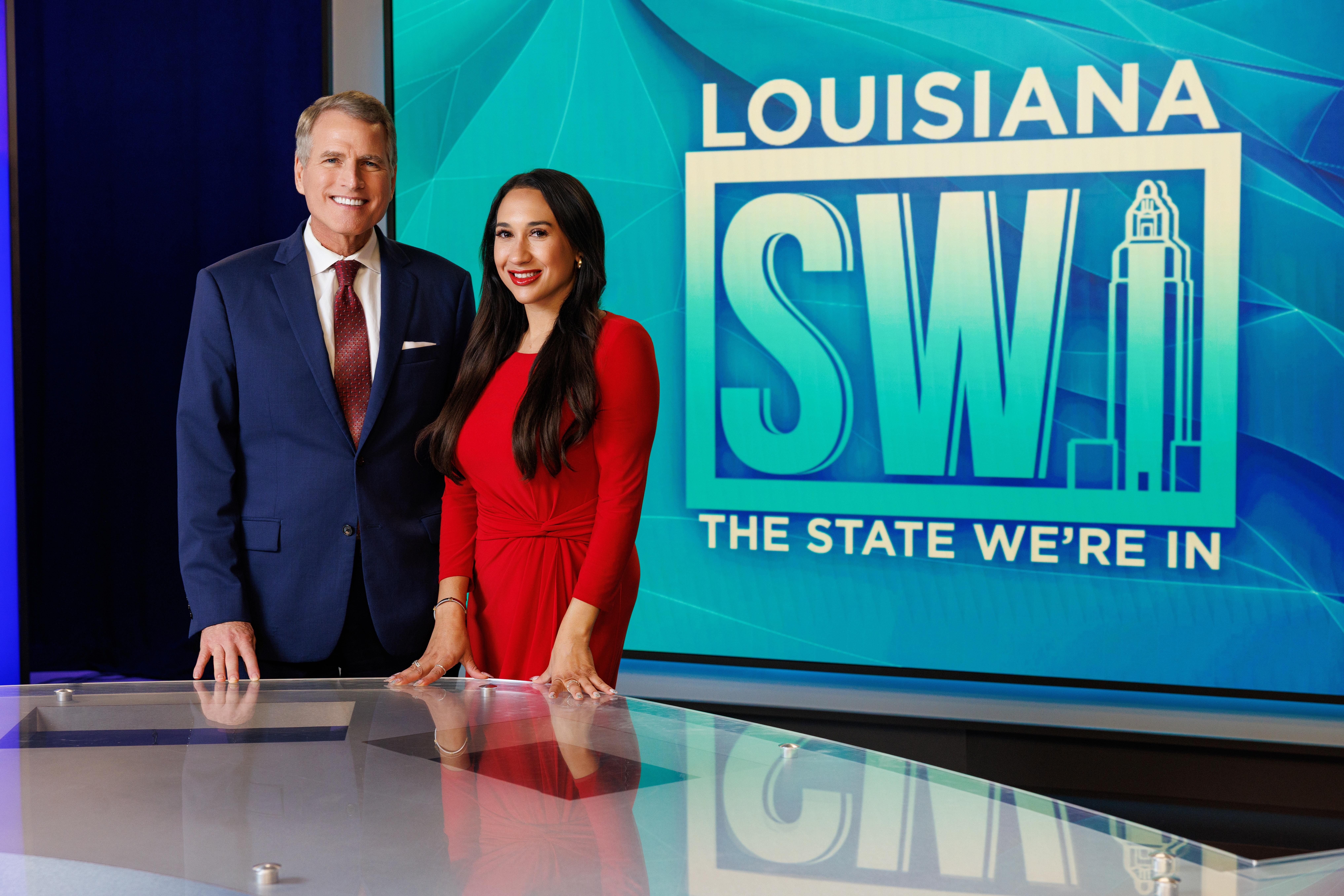 Johnny Atkinson and Christina Jensen stand next to one another on the set of the LPB weekly news and public affairs program Louisiana The State We're In.
