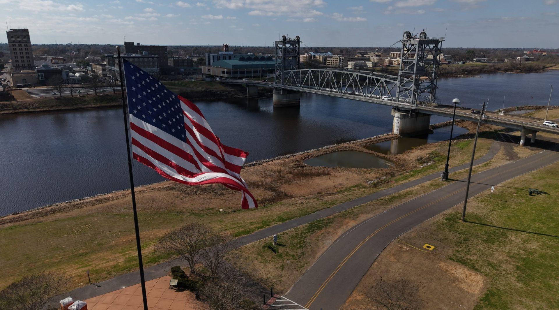 An aerial view of the Alexandria riverfront. An American flag waves in the breeze.