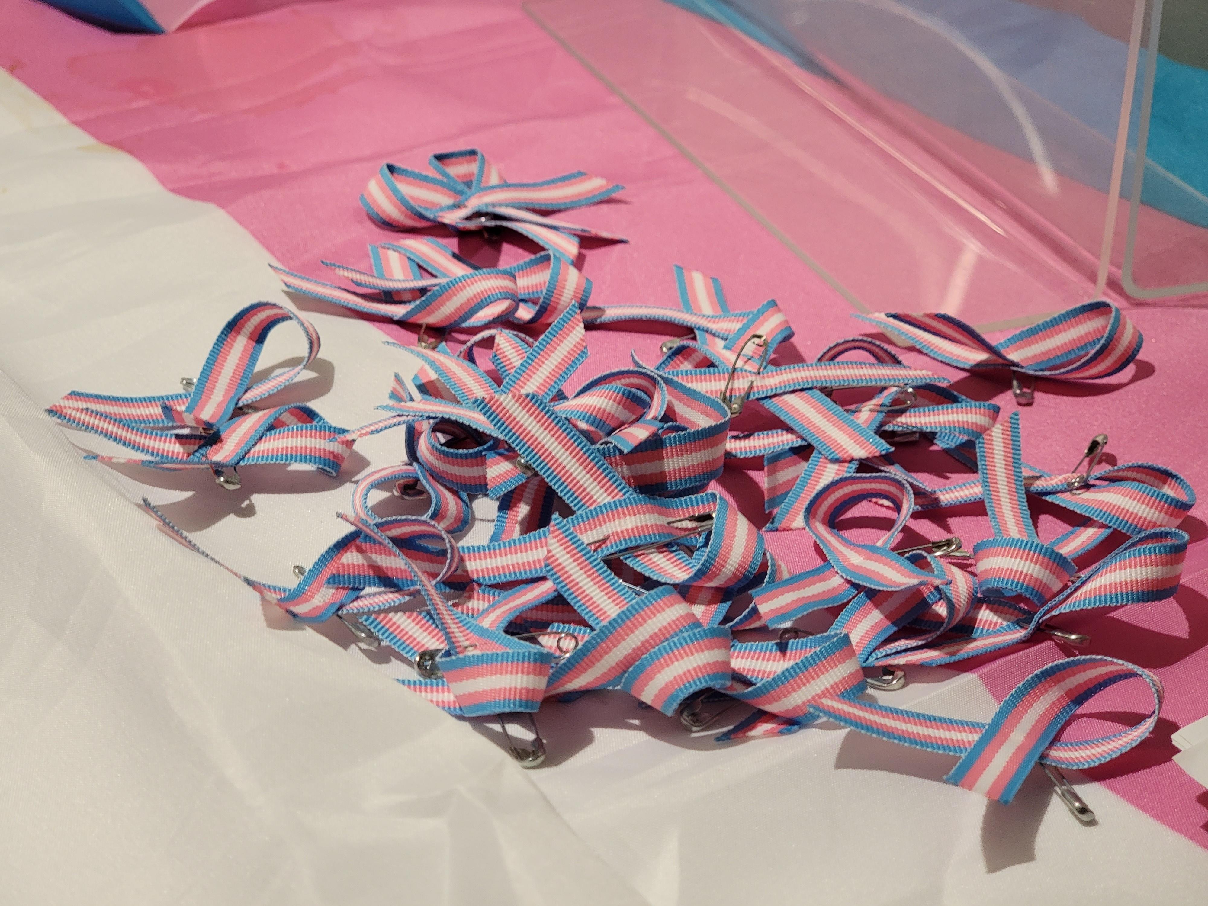 A collection of trans pride ribbons sit on a table at the 2021 Trans Day of Remembrance event