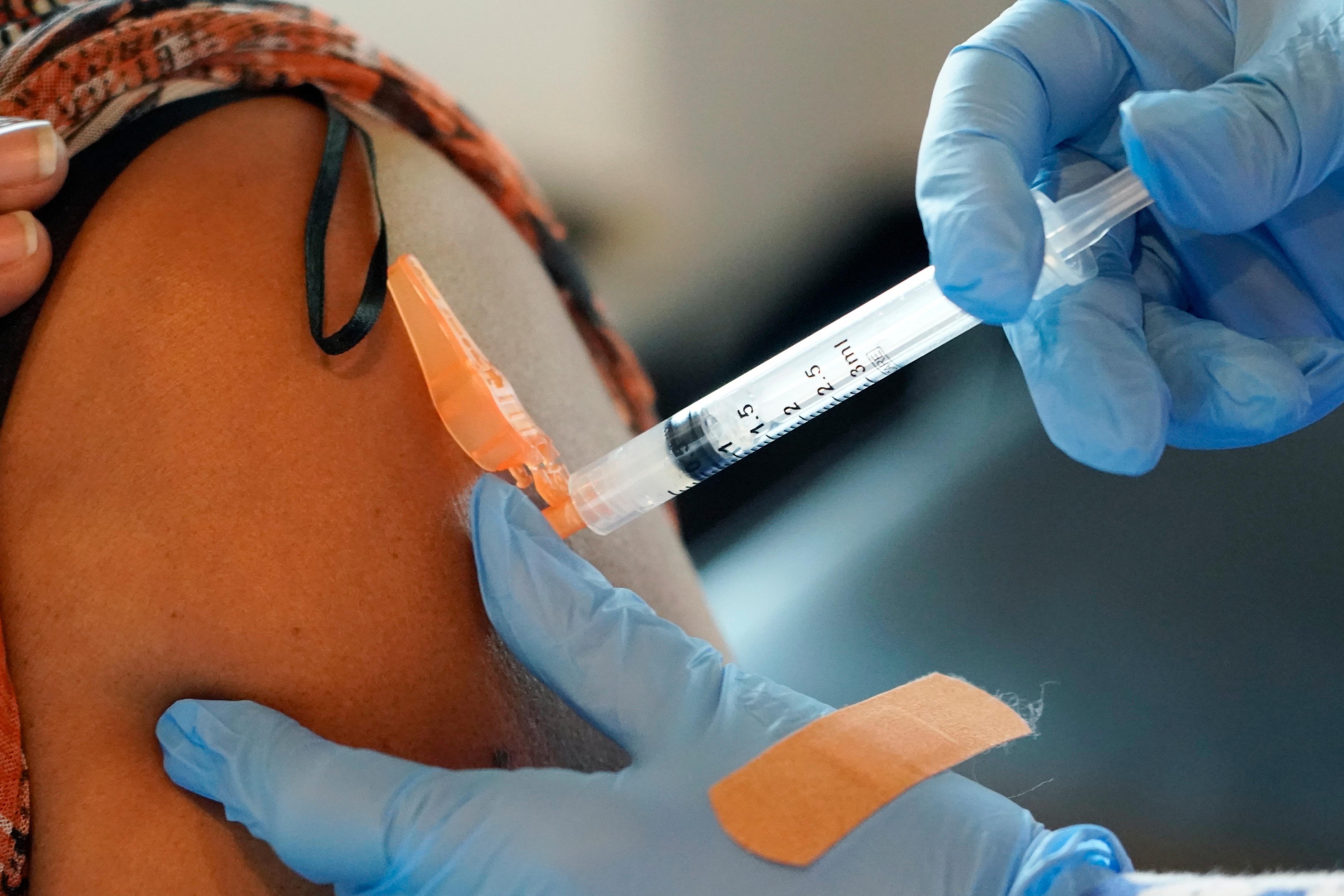 A person receives a shot in the arm from a health professional.