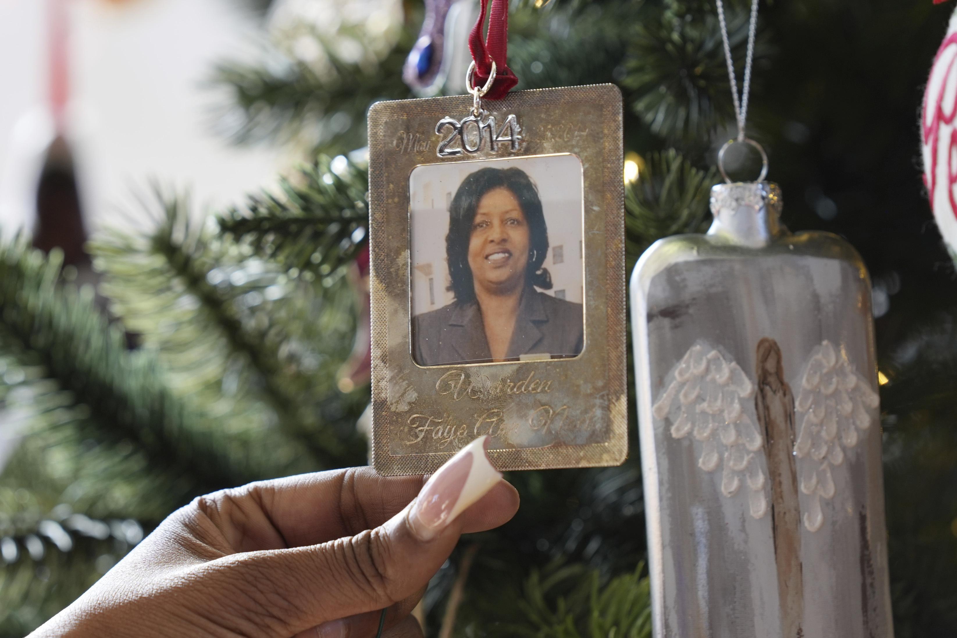 A young woman holds a metal ornament featuring the picture of her grandmother.