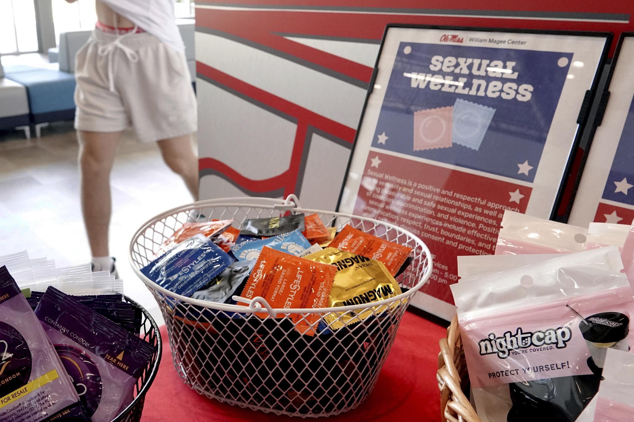 A white basket filled with condoms sits next to baskets of other contraceptives.