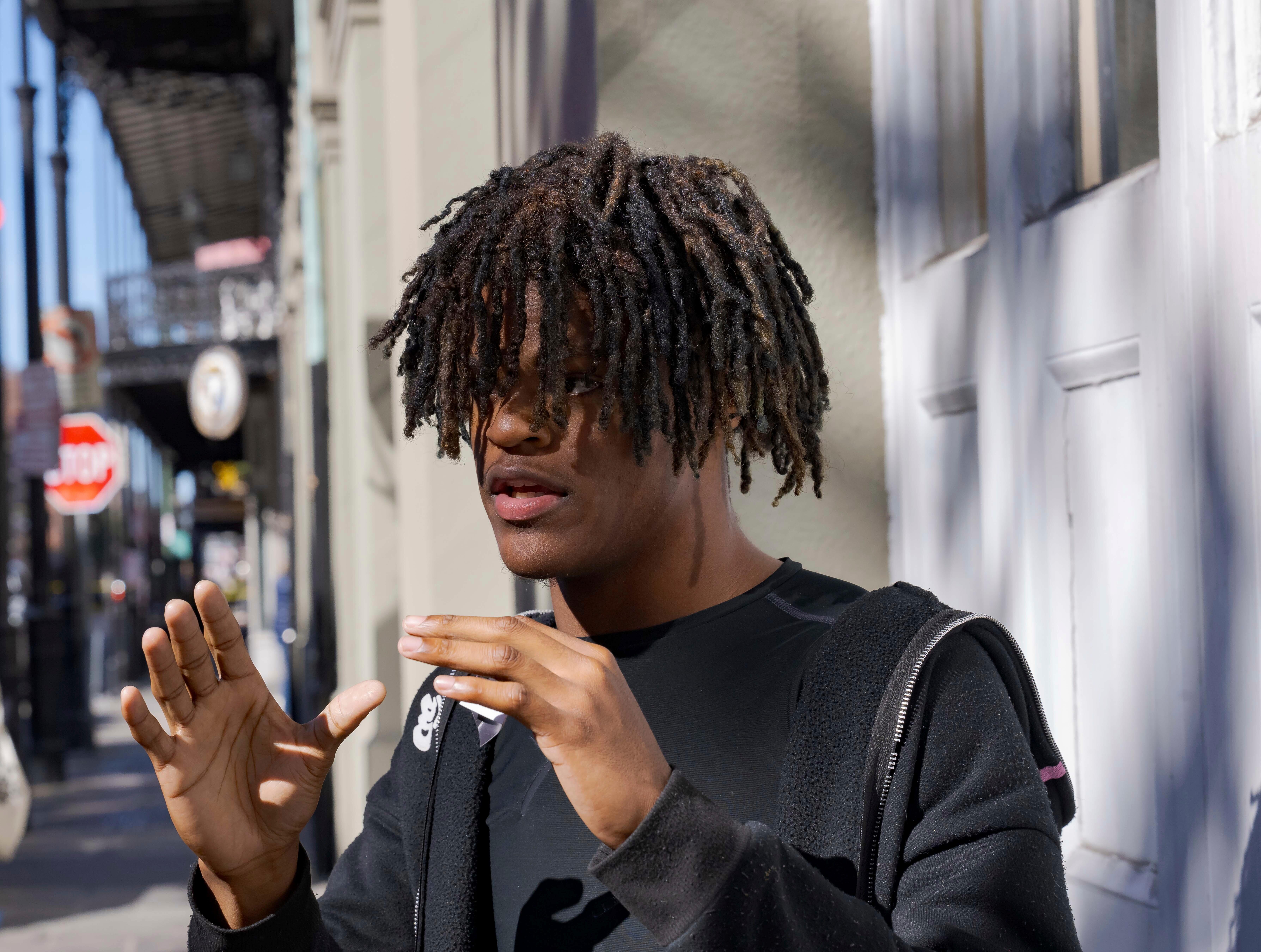 A young man raises his hands as he describes what he witnessed during a terrorist attack.