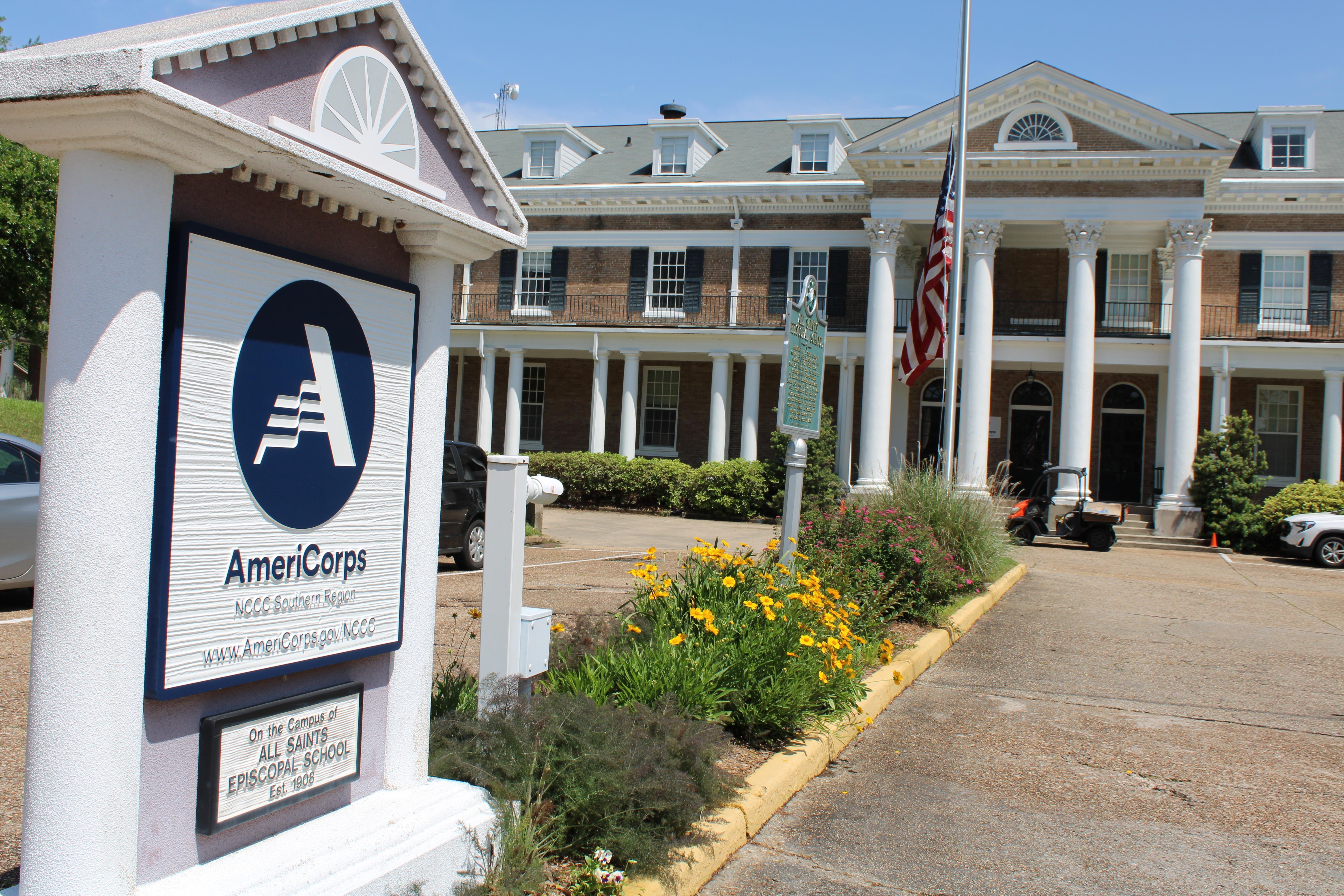 A sign featuring the name of an organization headquartered in a historic building is featuerd. 