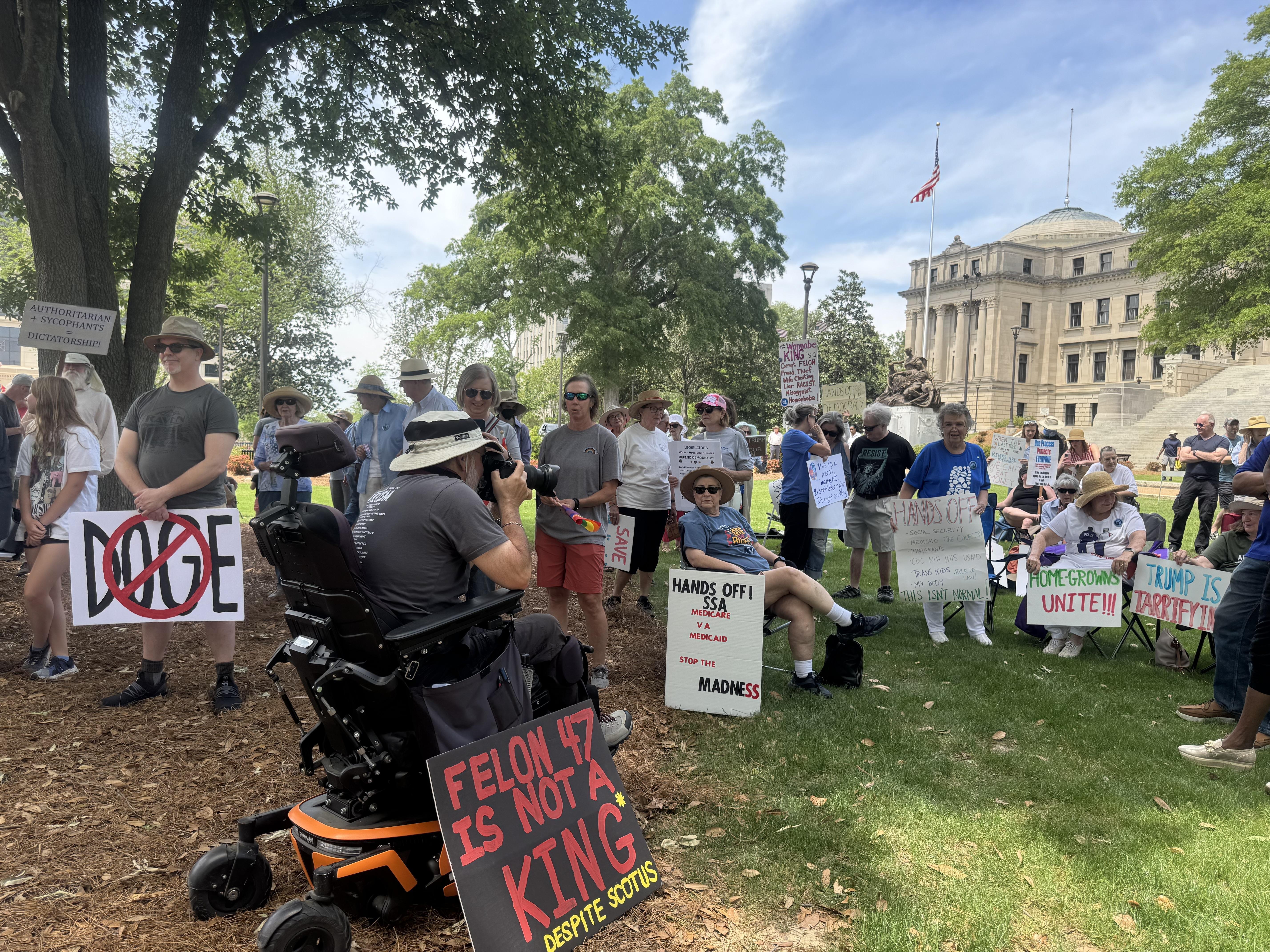 A group of protesters hold signs in front of Mississippi's state capitol building.