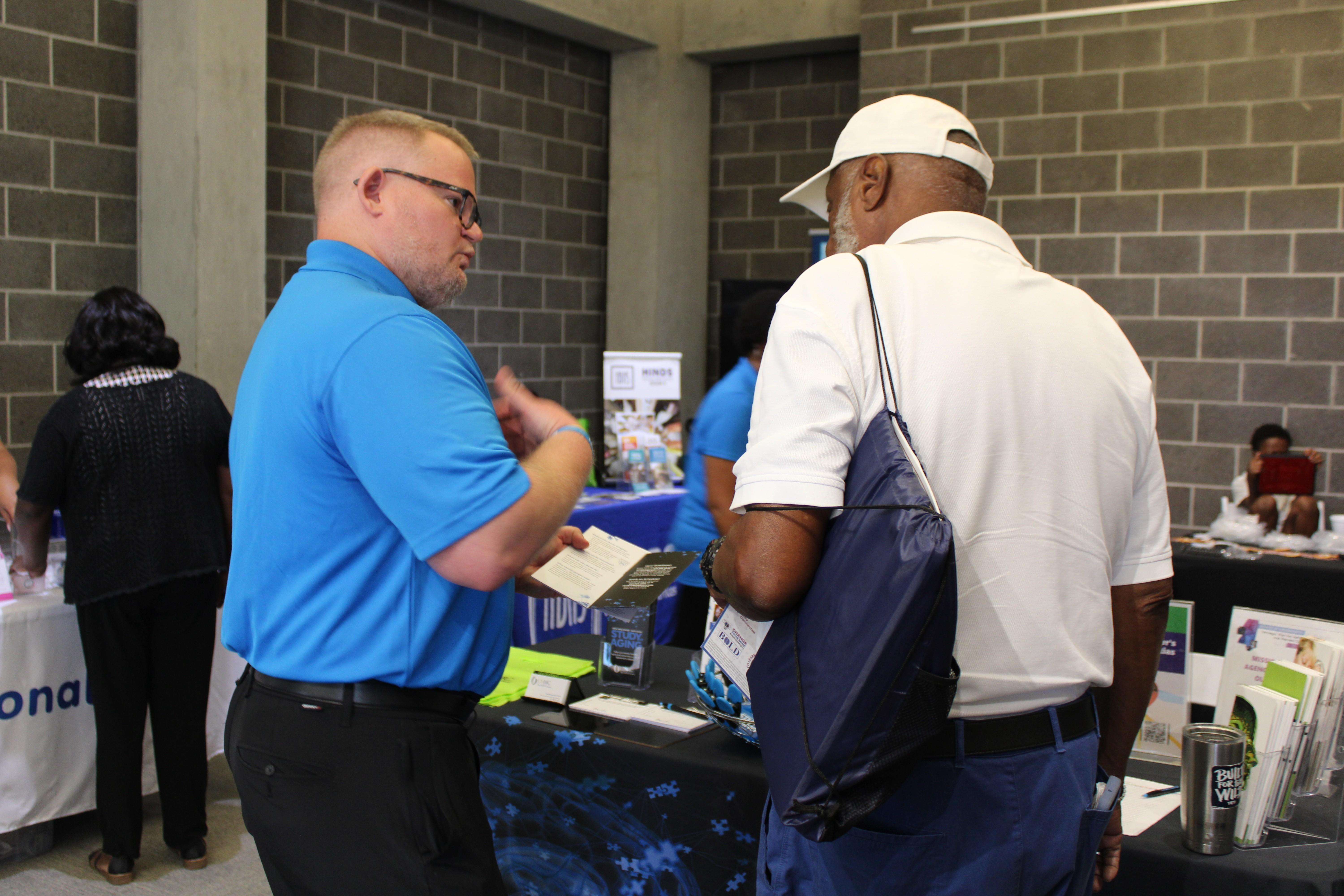 A public health worker speaks to another man.