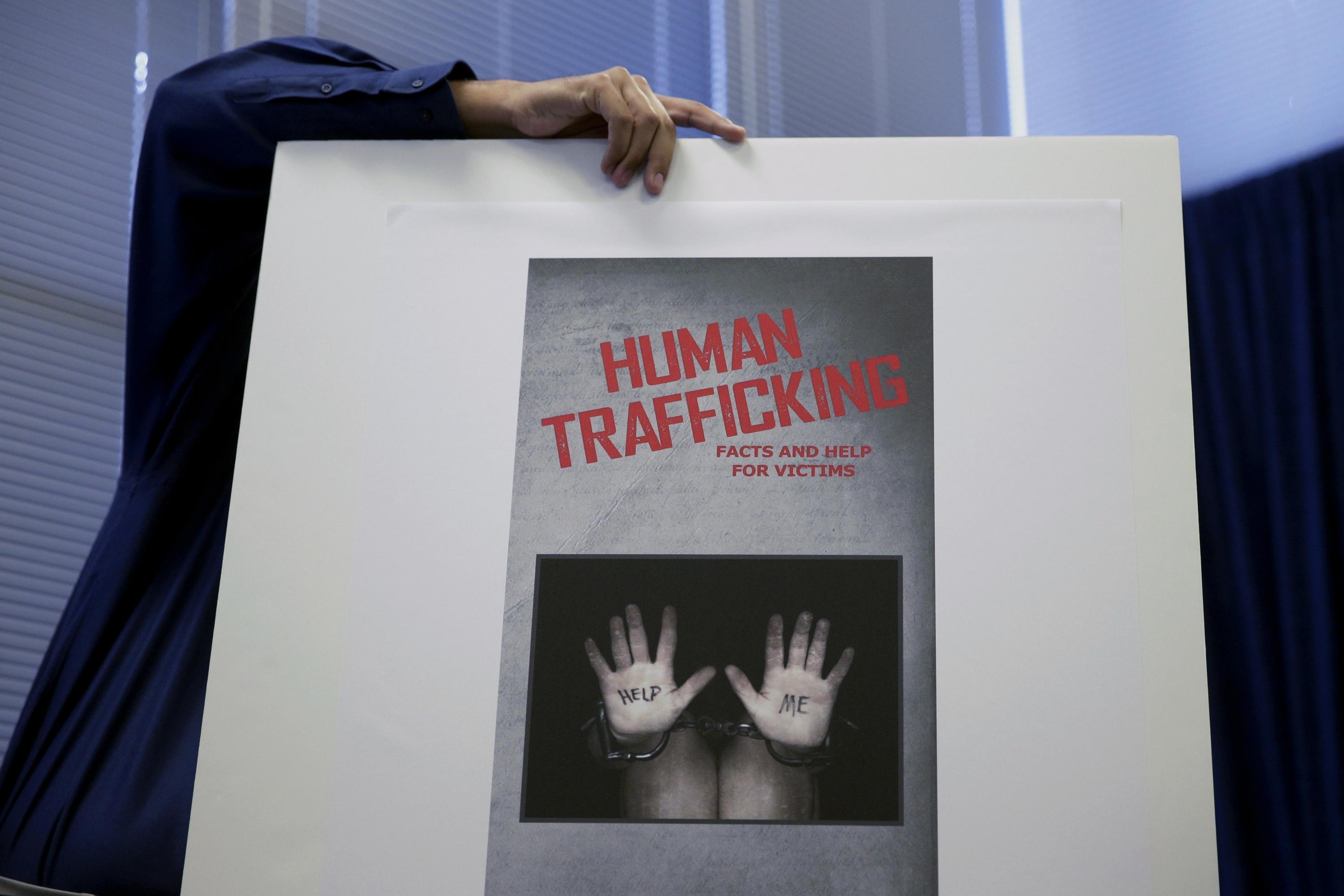 An employee holds up a sign with a message about human trafficking.